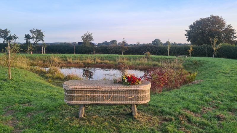 Wicker coffin placed by the pond at Aylesbury Vale natural burial ground
